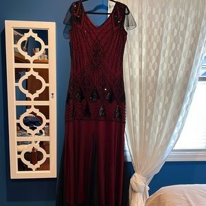 Red gown with black beads. Fully lined. 64” from shoulder to hem. Side zipper.